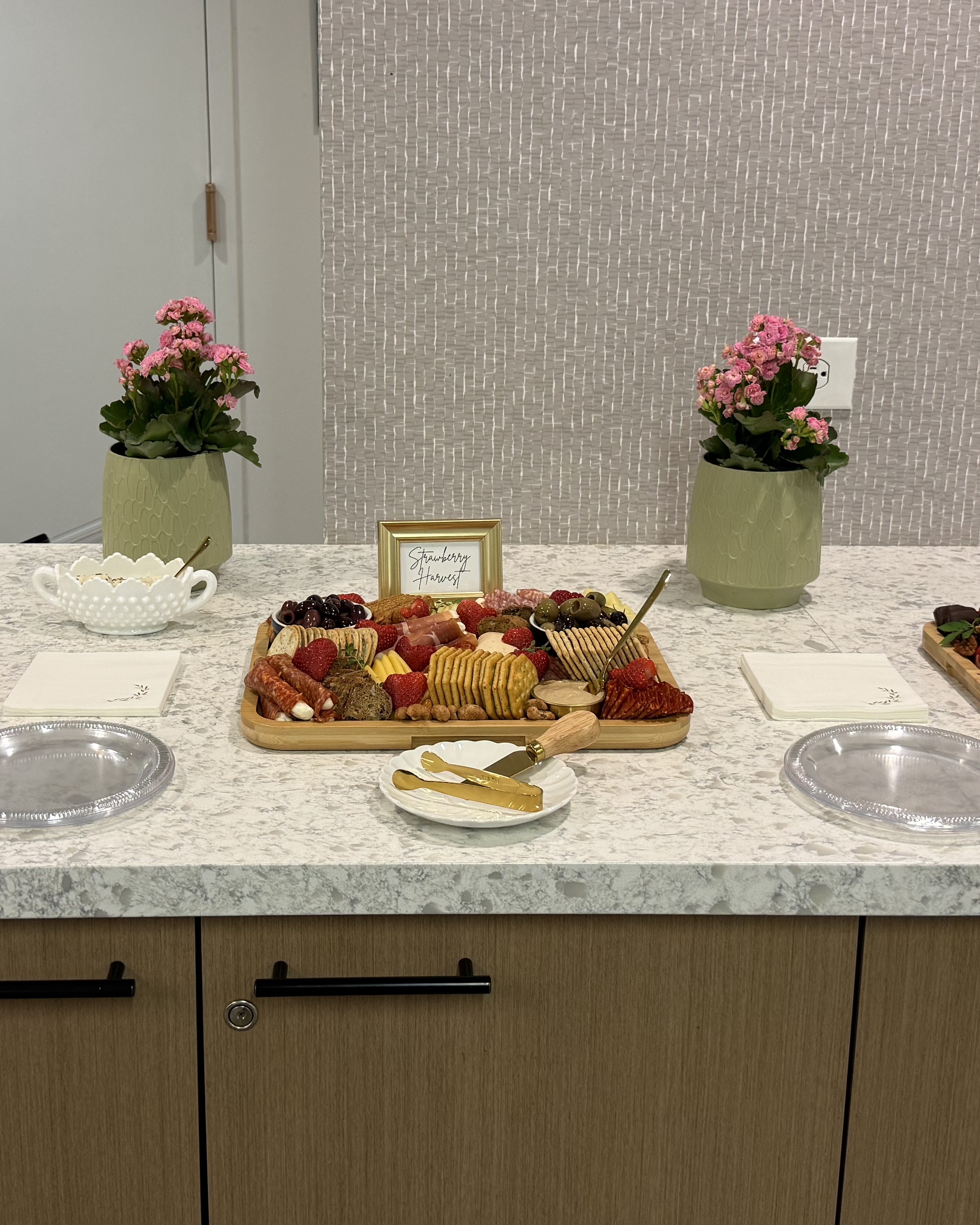 A charcuterie spread set out for guests, with a place card reading Strawberry Harvest